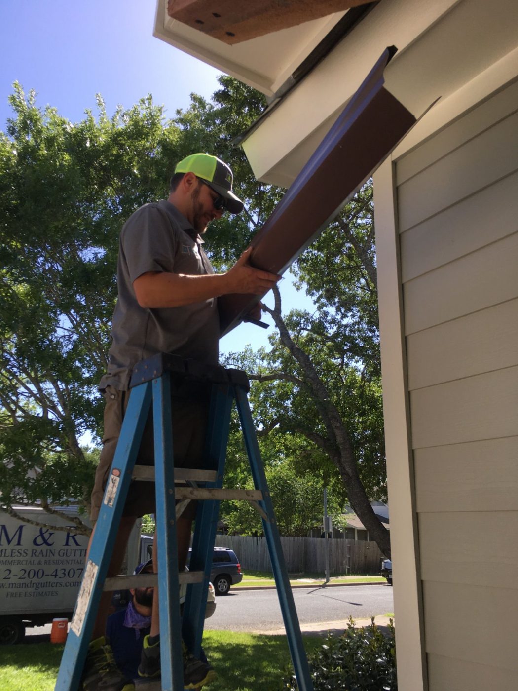 Gene installing a seamless downspout from a ladder