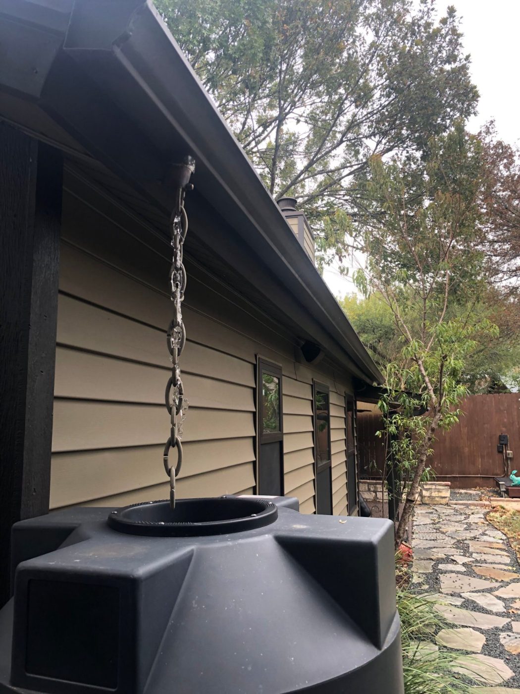 Rain chain feeding a rainwater collection tank